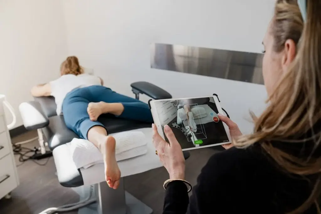 A podiatrist assessing a patient's foot and heel in the clinic room